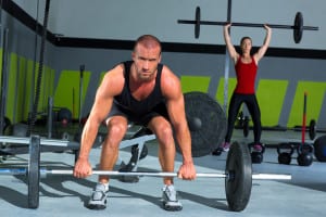 gym man and woman with weight lifting bar workout in crossfit exercise
